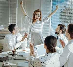 Team celebrating success with excitement and applause.