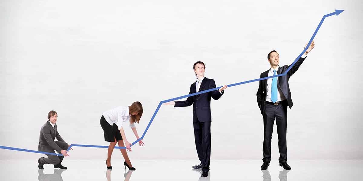 Team of professionals collaborating in an office, illustrating business growth with an upward-trending graph on a screen — representing digital strategies used to grow and scale your restoration business through consistent lead generation and performance tracking.