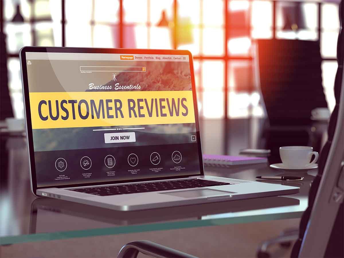 Restoration Company Reviews Laptop with customer reviews webpage open.