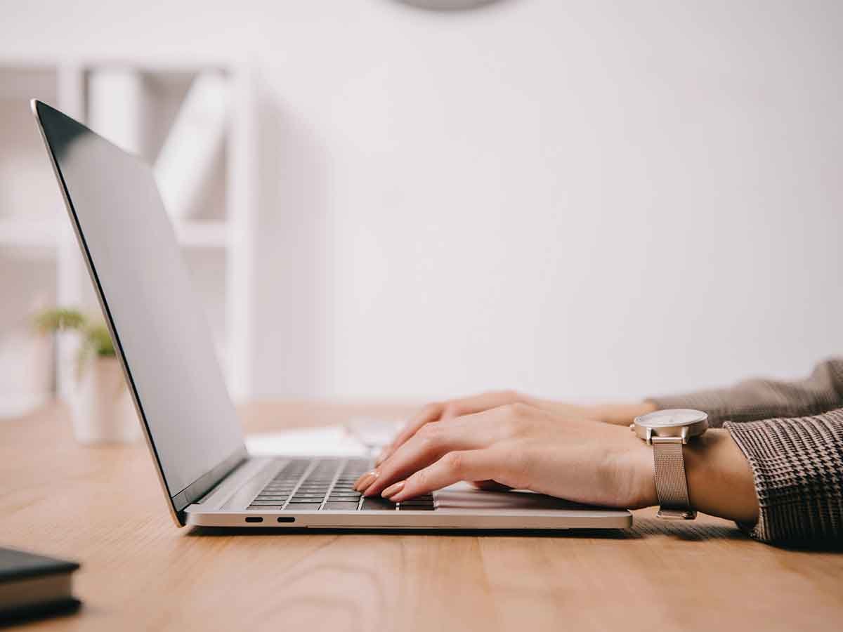 Restoration Website - The Restoration Marketers Person typing on a laptop at a desk - Restoration Website